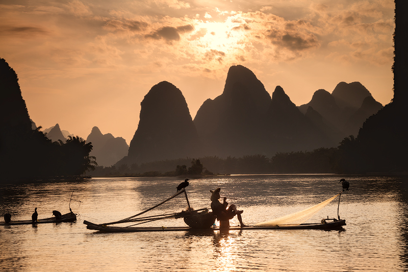 asia,asian,boat,china,chinese,cormorant,environmental portait,evening,fisherman,fishing boat,guilin,hill,karst,karst mountains,landscape,li river,male,man,mountain,mountain range,people,portrait,range