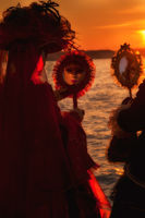 Carnival models admiring themselves in a mirror at sunset.