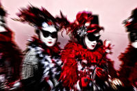 Zoom shot of Venice Carnival models in red, black and white.