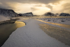 Changing weather and low-angled sunlight create otherworldly conditions on a beach in Norway.