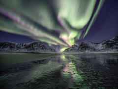 An amazing aurora borealis display on a lonely beach in Norway.
