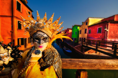 Yellow-costumed model on a bridge on Burano Island during Carnival.