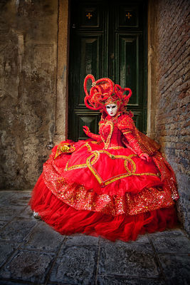 Red costumed model in a Venice doorway during the Carnival celebration.