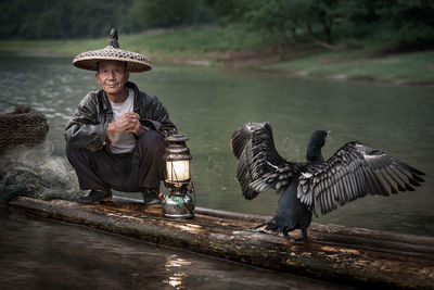 A Chinese fisherman posing next to his Cormorant.