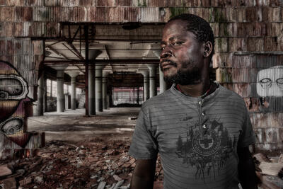 Compositve of a Malawian man in an abandoned factory in Indiana.