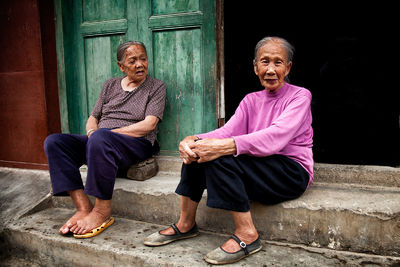 Neighbors in a village in China conversing outside their homes.