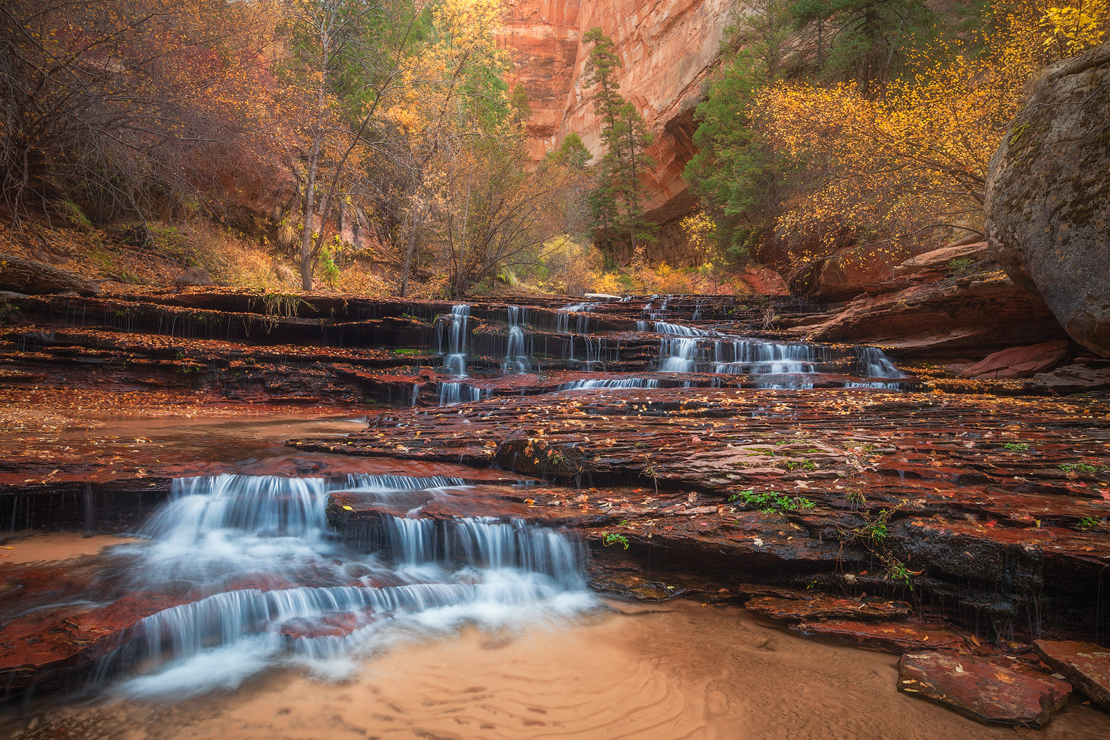 Beautiful Fall foliage atop a waterfall located deep inside a valley.