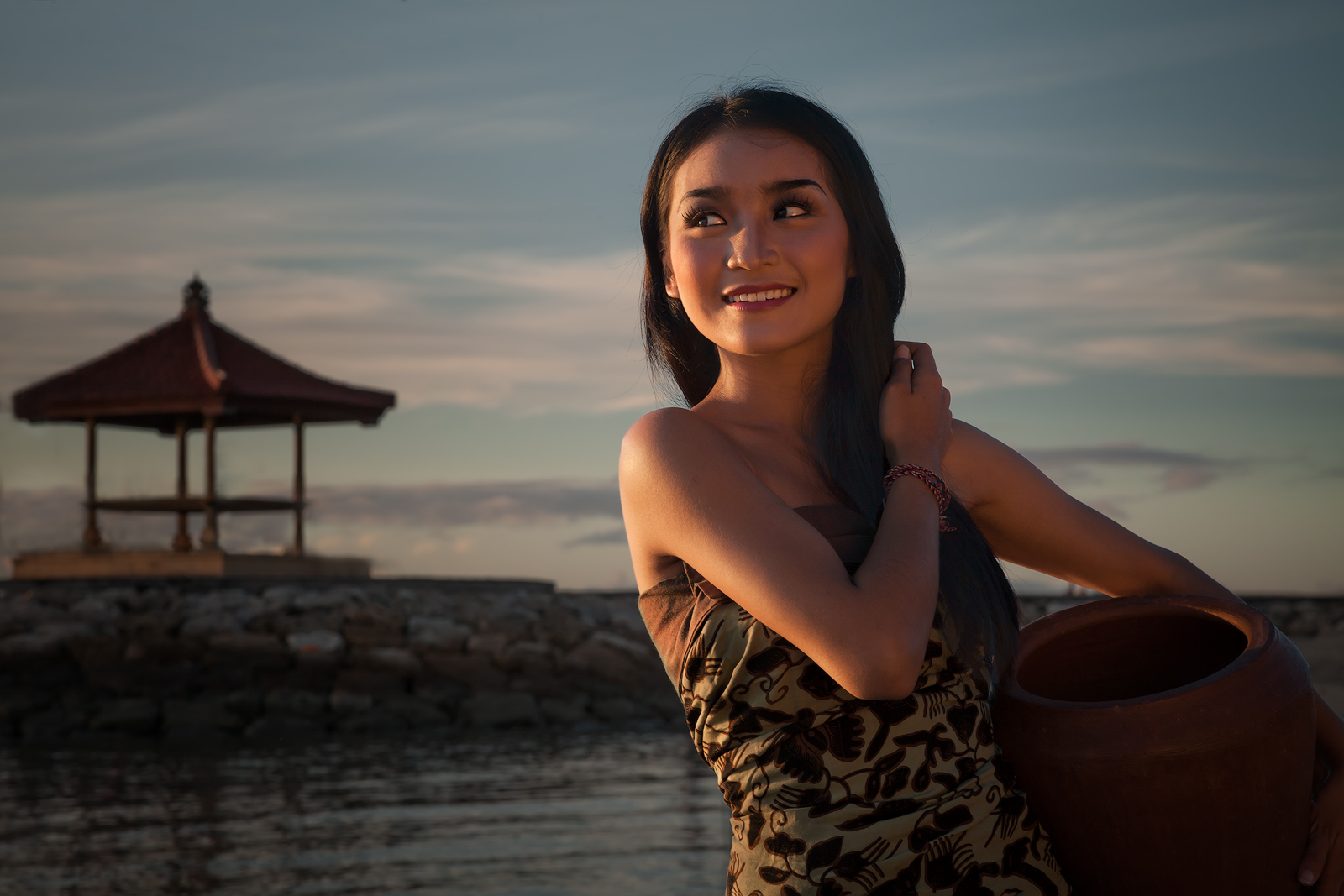 Beautiful Balinese girl on the beach at sunrise.