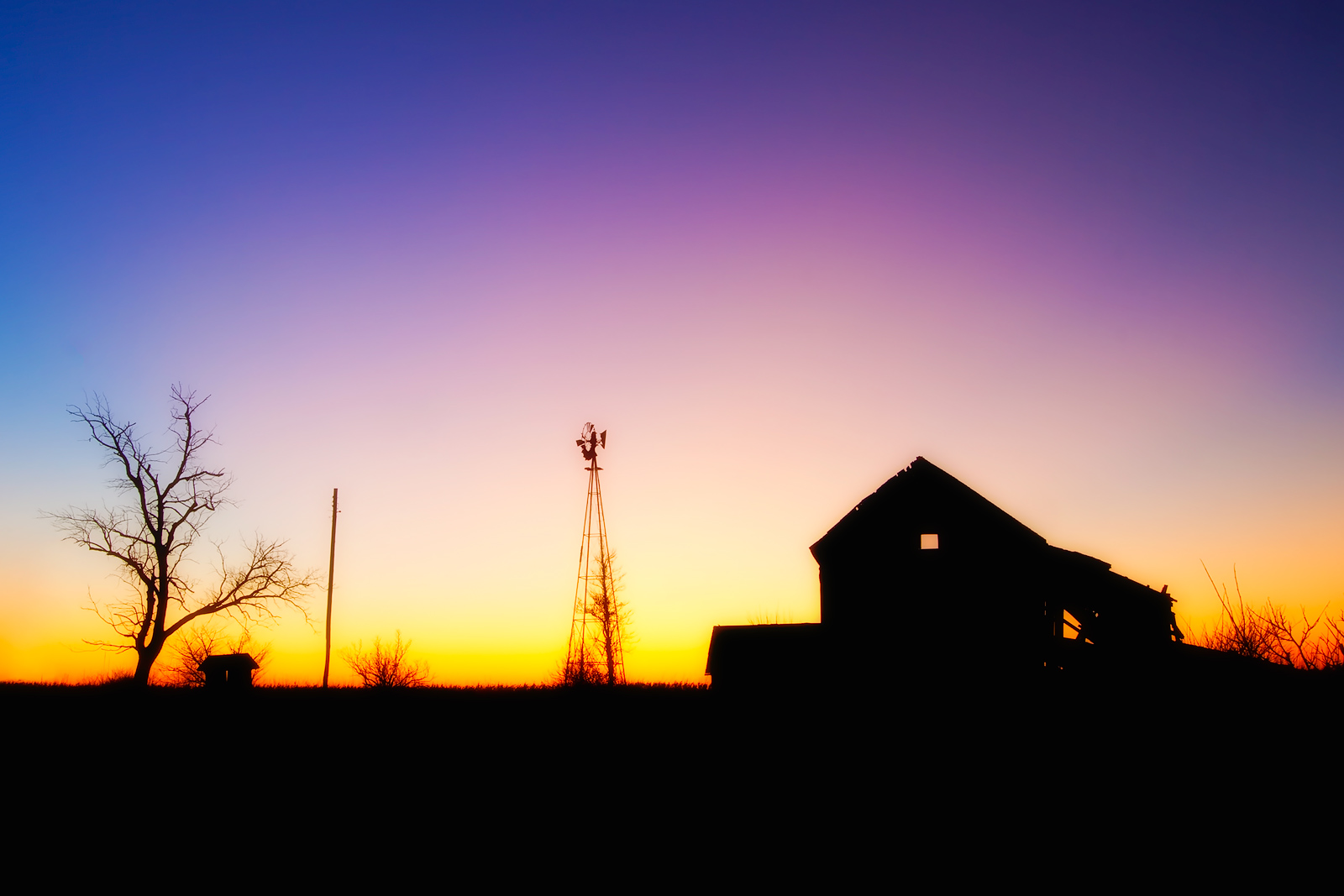 Colorful sunset silhouette of an Illinois farm.