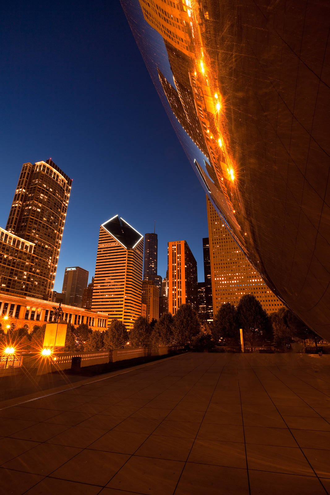 Chicago's Bean in front of skyscrapers at night