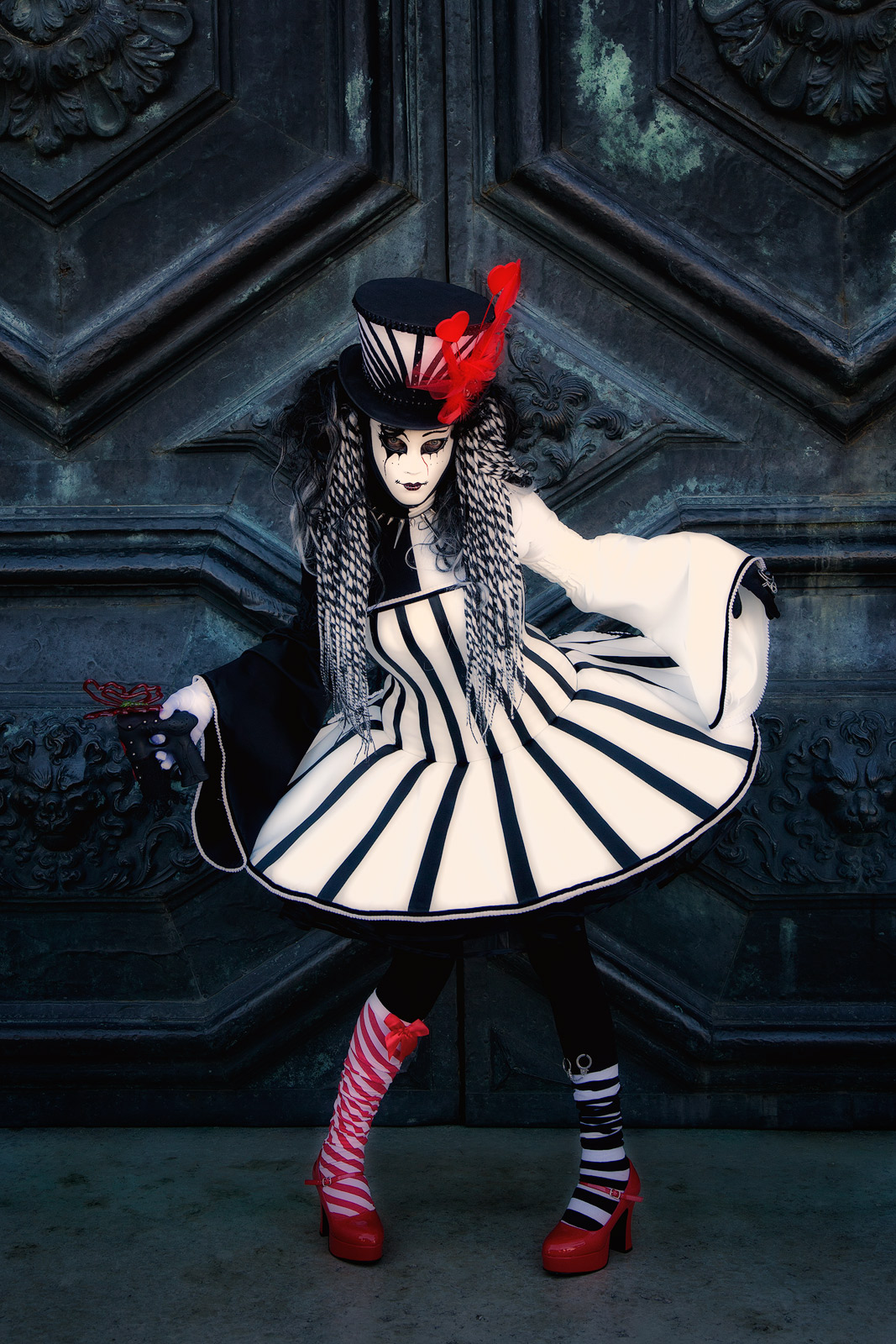 Carnival model in black, white and red in front of a church door.