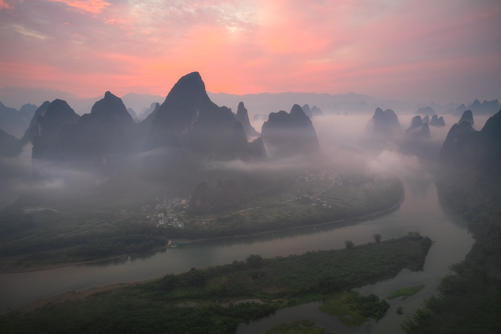 Early morning up high on a mountain overlooking a majestic view of the Li River and karst mountains.