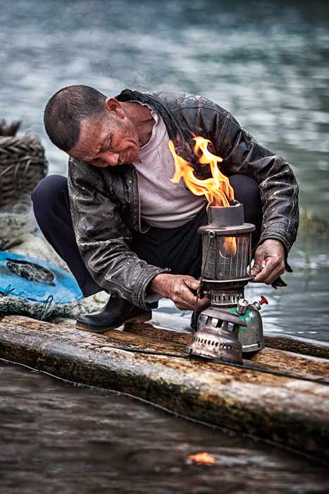 Chinese fisherman lighting a lantern