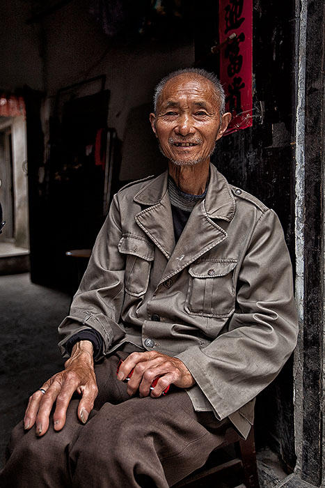 Portrait of older Chinese man sitting down