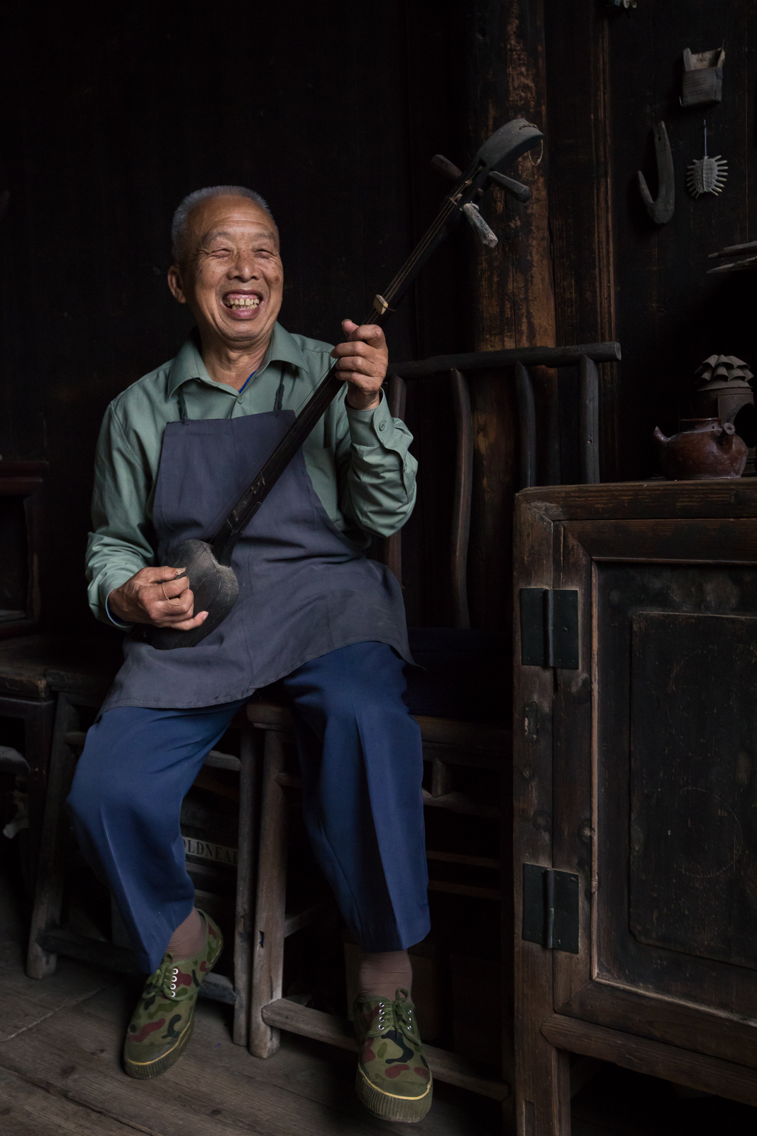 A Chinese man laughing while singing an old folk song.
