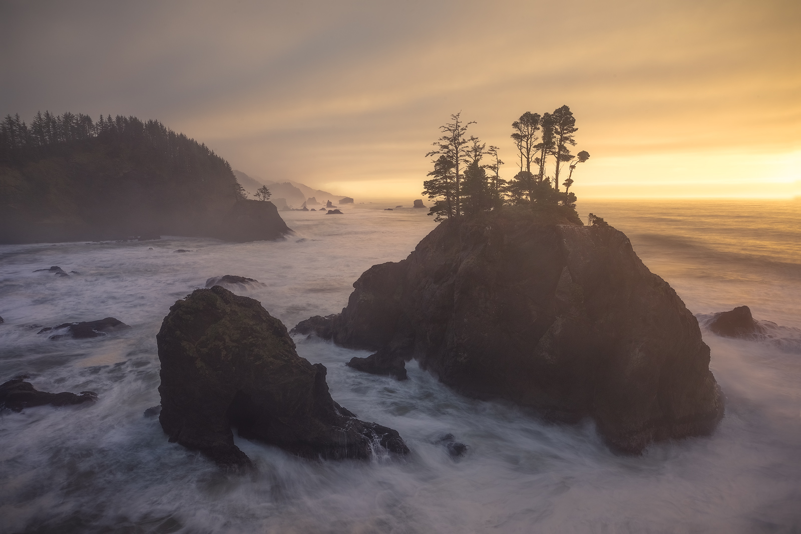Powerful waves crashing against seastacks at sunset.