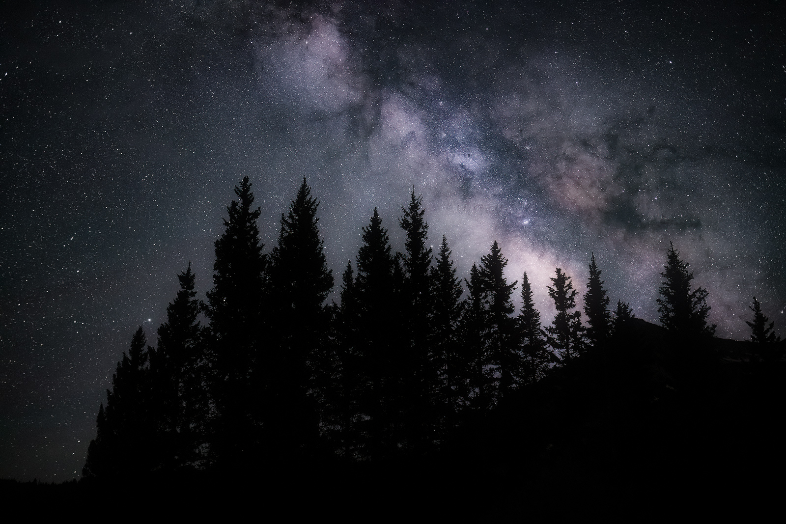 The Milky Way behind a Colorado hilltop in early Summer.