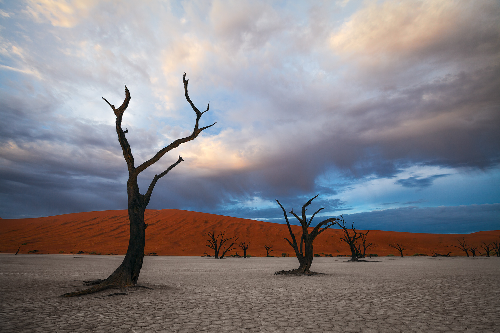Morning clouds leave the orange dunes in shadow