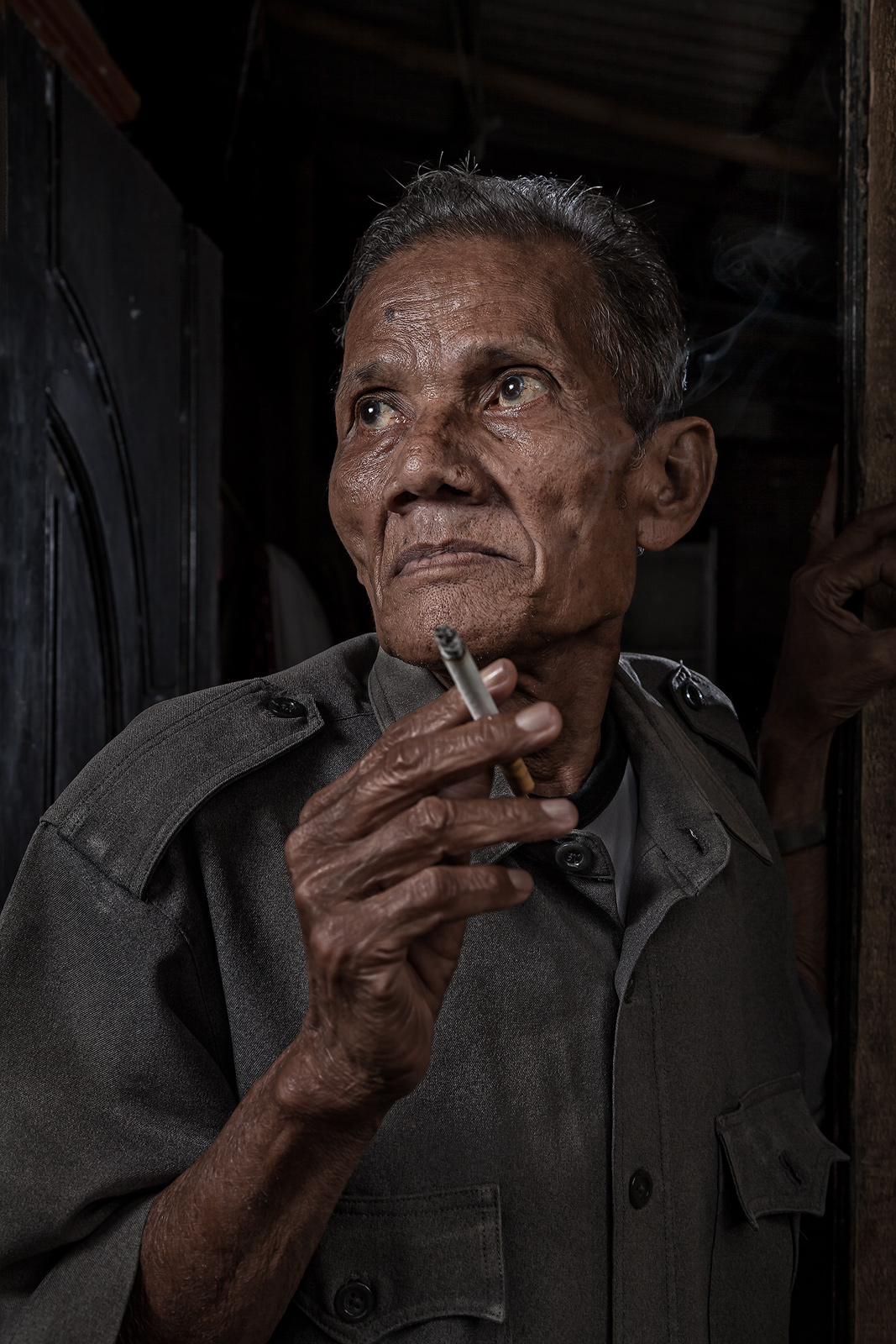 Indonesian man having a morning smoke in a village outside Jakarta