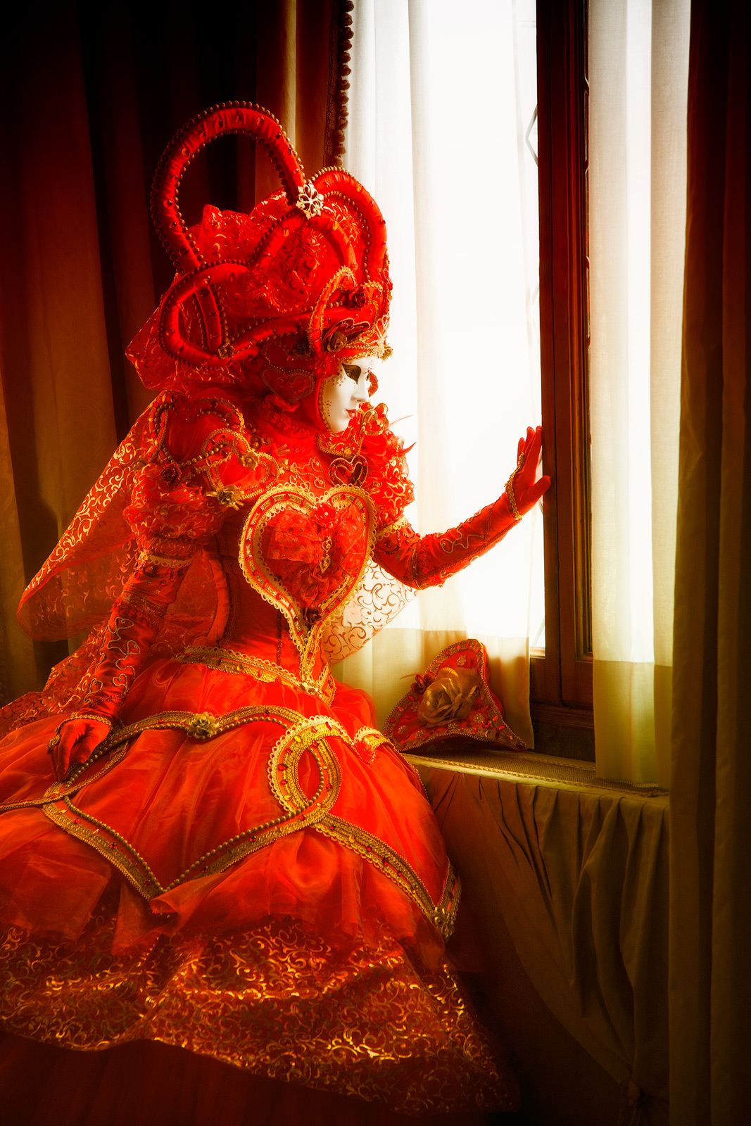 Beautiful costumed model looking out her window to the streets of Venice below.