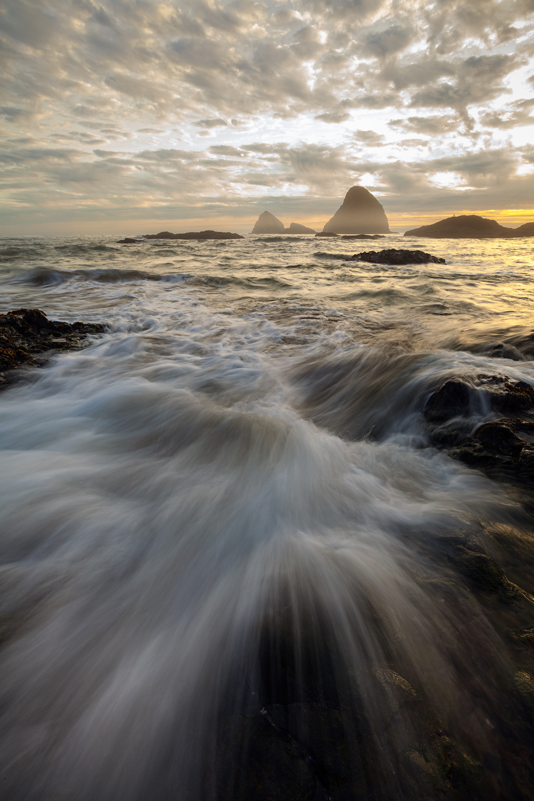 A wave crashing on the rocky shore of Oceanside, Oregon is frozen in time