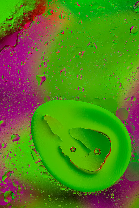 Pink and green oil and water close-up