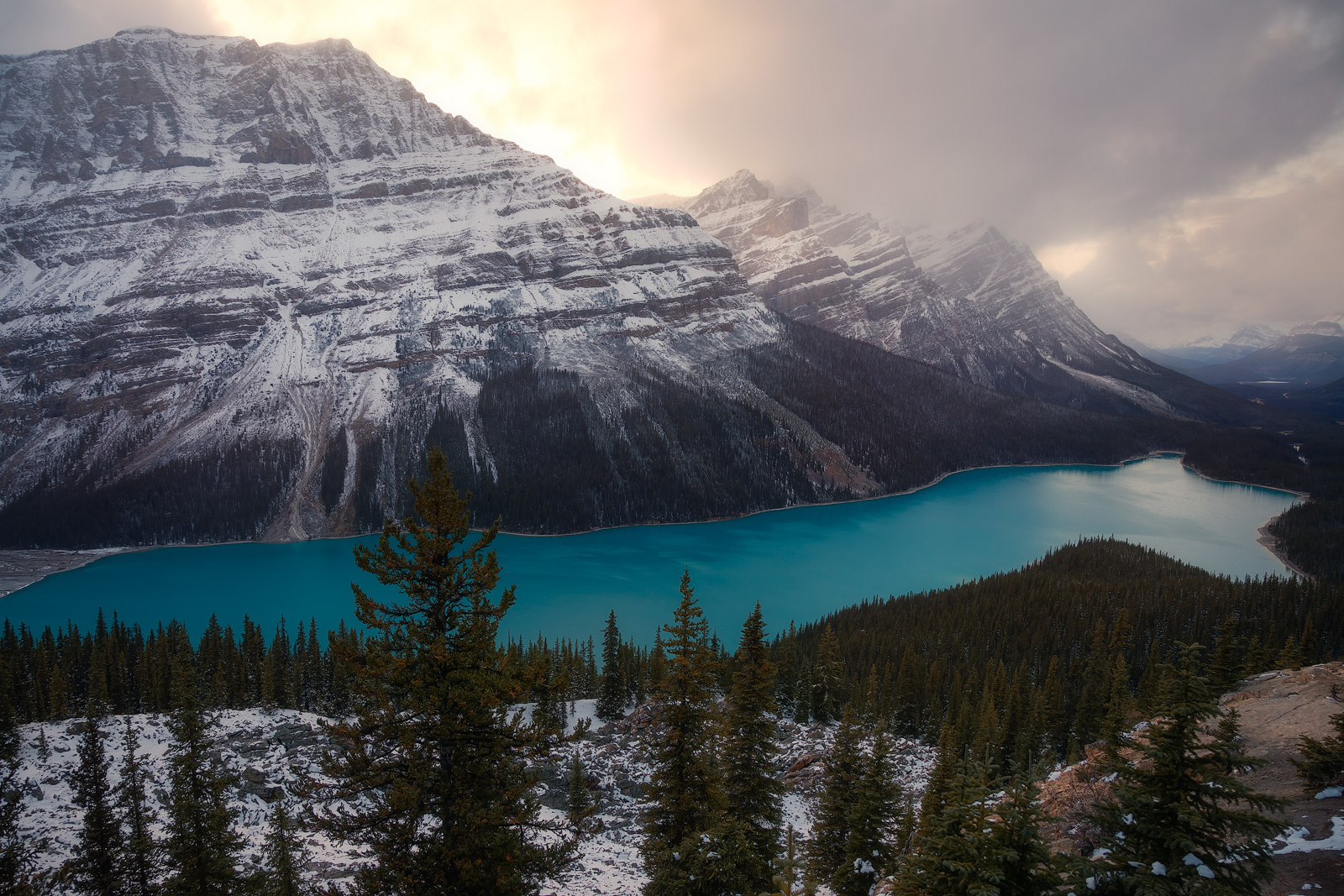 Light breaking through over a snow-covered mountain in the Canadian Rockies.