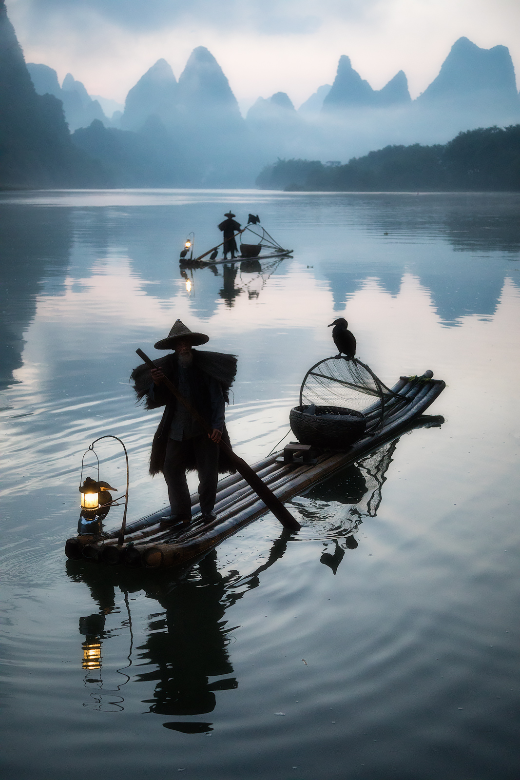 A ripple from the fisherman's oar surrounds his raft on the Li River.