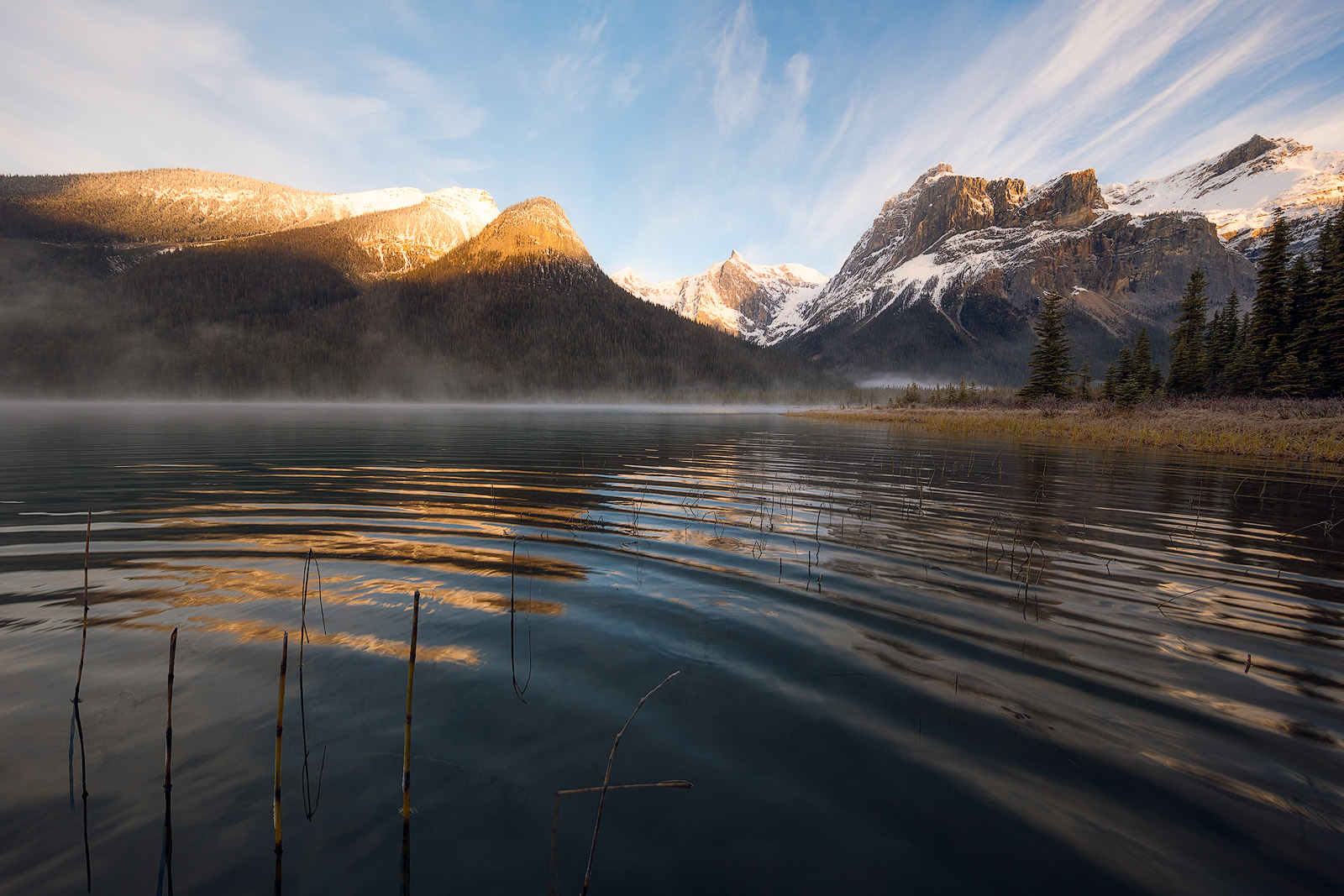 The ripple of a wave cuts through reflections of the mountains beyond Emerald Lake.