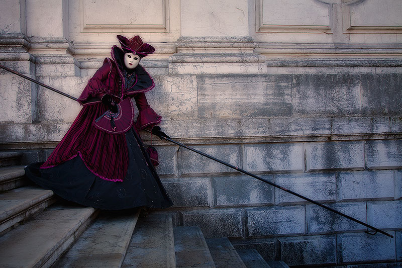Model in a beautiful dark purple costume on the stairs at San Gorgio church