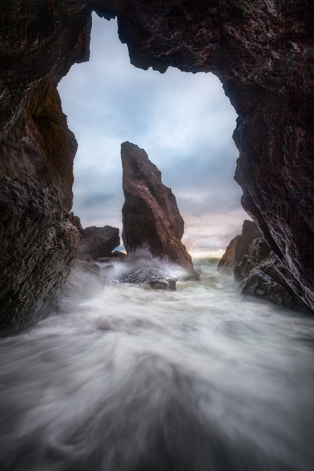 A lone sea stack sits vulnerable to powerful rushing waters.