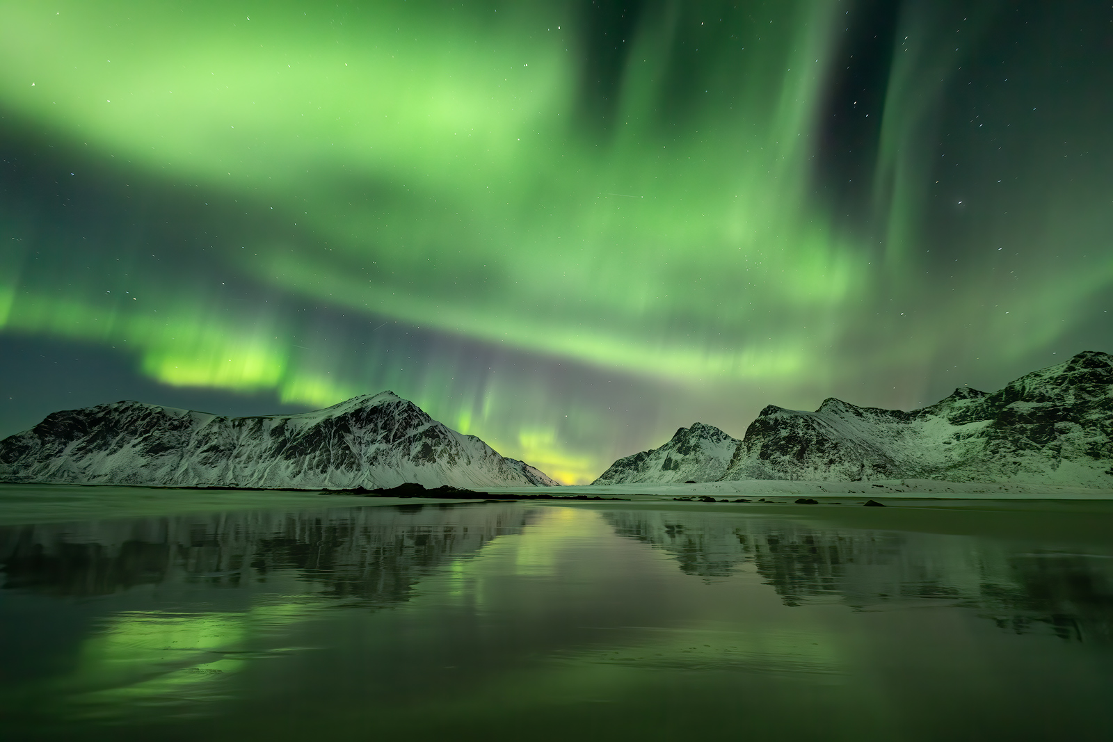 Amazing aurora display reflecting on Skagsanden Beach.