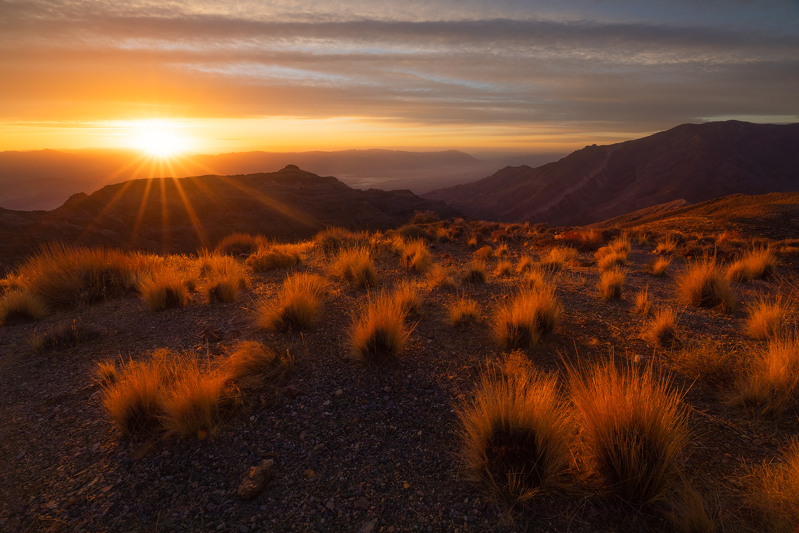 A break in the clouds allows warm sunlight to illuminate the foreground in a brilliant display.