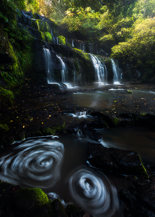 Sun rays coming down over Purakaunui Falls in The Caitlins.