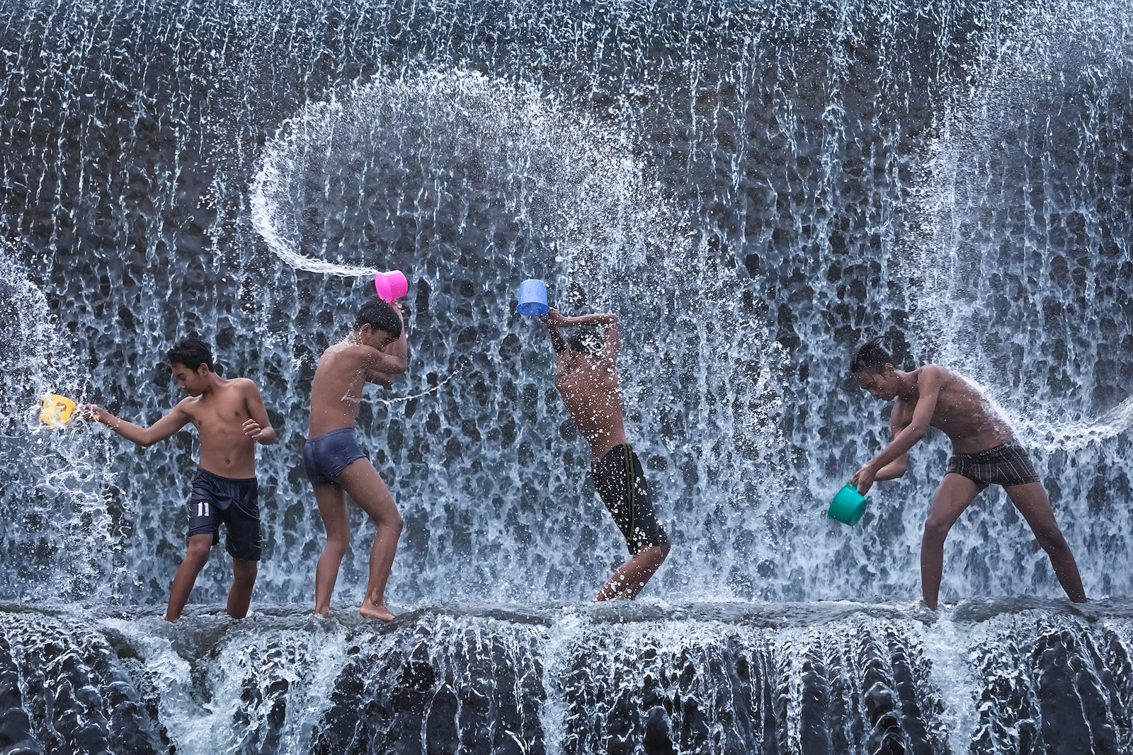 Children playing with water in a dam on Tukad Unda River
