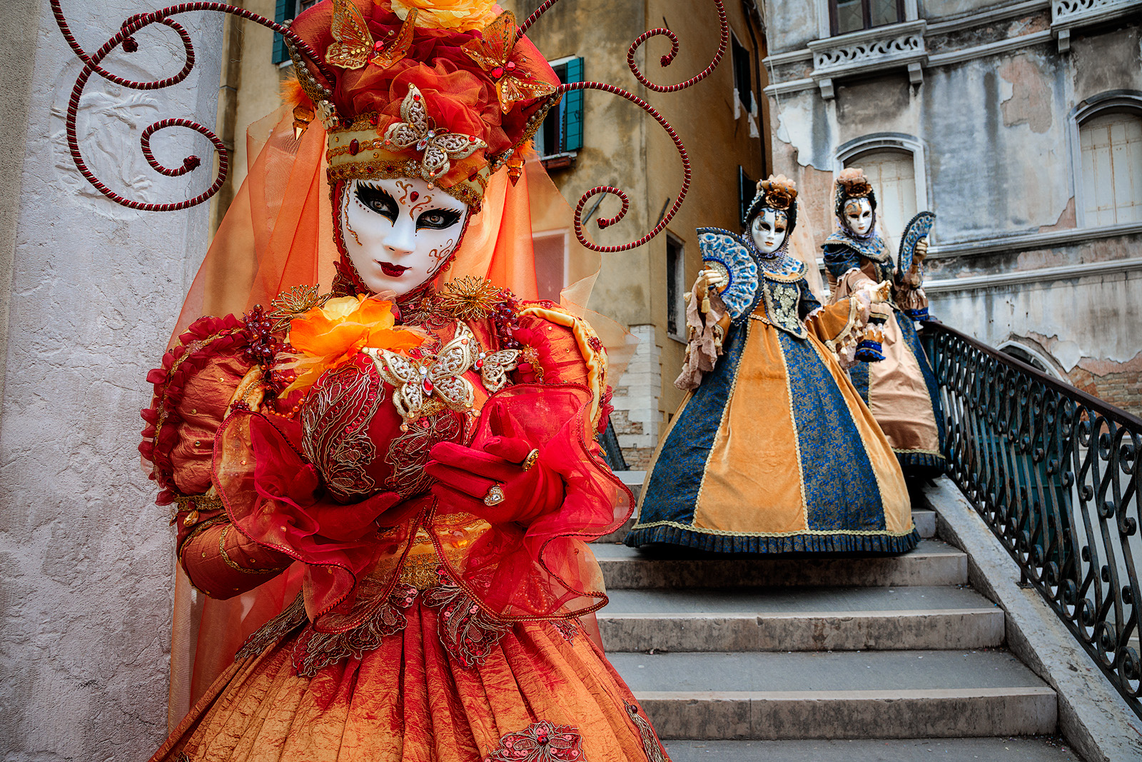 Elegant Carnival models posing on a stairway in Venice.