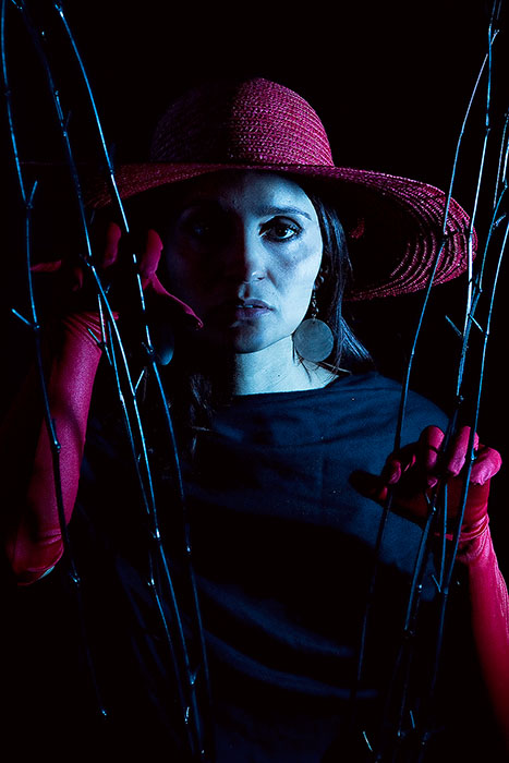 Distressed looking woman wearing a red hat in a dark room